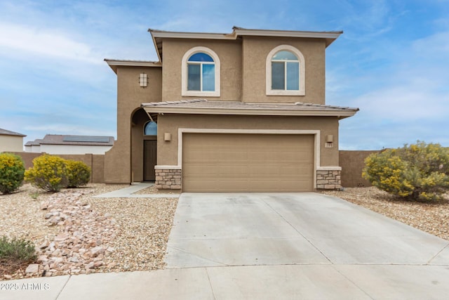 view of front of home featuring concrete driveway, a garage, stone siding, and stucco siding