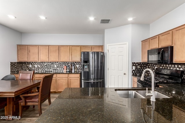 kitchen featuring tasteful backsplash, visible vents, black appliances, and a sink