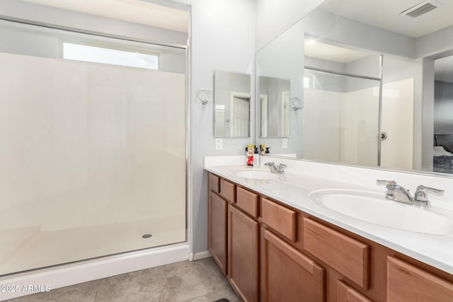 bathroom with a stall shower, visible vents, and a sink