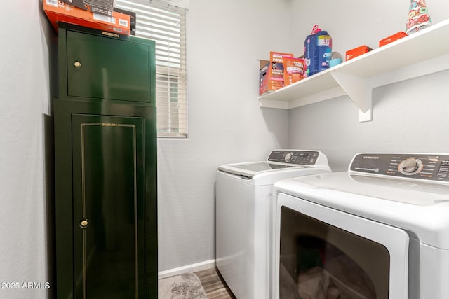 laundry area featuring washer and clothes dryer, laundry area, baseboards, and wood finished floors