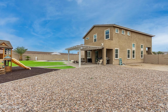 rear view of house featuring stucco siding, a pergola, a fenced backyard, a playground, and a patio area