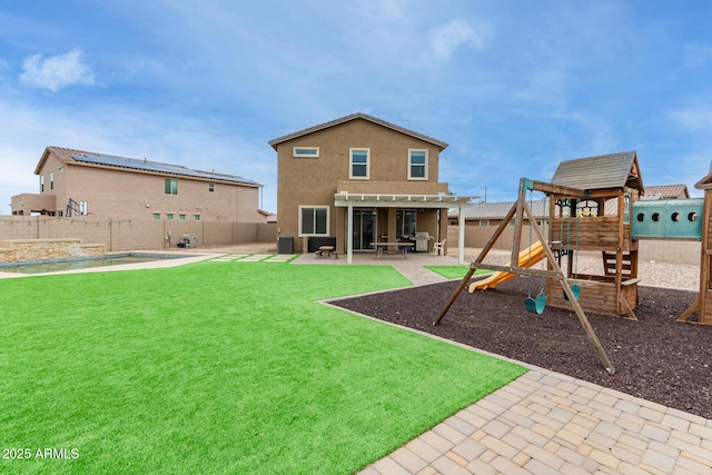 rear view of house with a patio, a fenced backyard, a pergola, stucco siding, and a playground