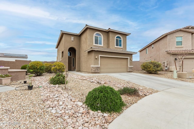 view of front of home featuring stone siding, stucco siding, an attached garage, and concrete driveway