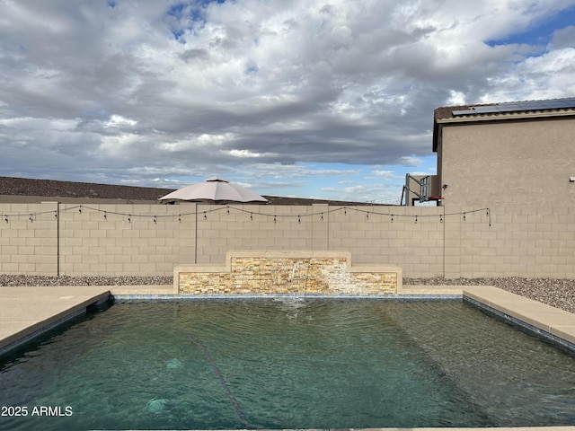 outdoor pool with a fenced backyard