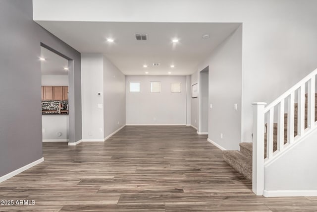 interior space featuring visible vents, baseboards, stairway, recessed lighting, and wood finished floors