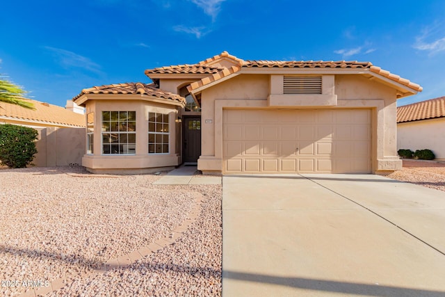 1627 W Maplewood St, Chandler, AZ 85286 - mediterranean / spanish home featuring a garage, stucco siding, driveway, a tile roof, and a gate