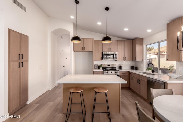 1627 W Maplewood St, Chandler, AZ 85286 - kitchen featuring appliances with stainless steel finishes, a sink, arched walkways, tasteful backsplash, and lofted ceiling