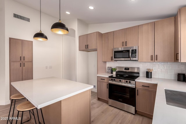 1627 W Maplewood St, Chandler, AZ 85286 - kitchen with appliances with stainless steel finishes, light wood-style floors, decorative backsplash, a kitchen bar, and vaulted ceiling