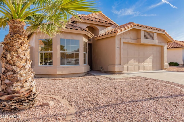 1627 W Maplewood St, Chandler, AZ 85286 - mediterranean / spanish house with stucco siding, concrete driveway, a tiled roof, and an attached garage