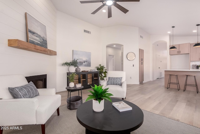 1627 W Maplewood St, Chandler, AZ 85286 - living area featuring arched walkways, light wood-type flooring, a ceiling fan, a fireplace, and recessed lighting
