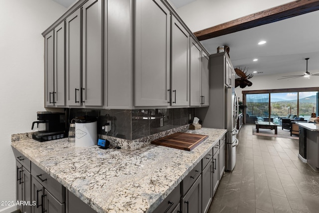 kitchen with light stone counters, recessed lighting, gray cabinetry, a ceiling fan, and tasteful backsplash