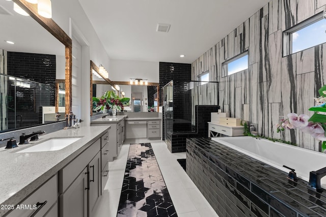 bathroom with a stall shower, tile patterned floors, a sink, and a bath