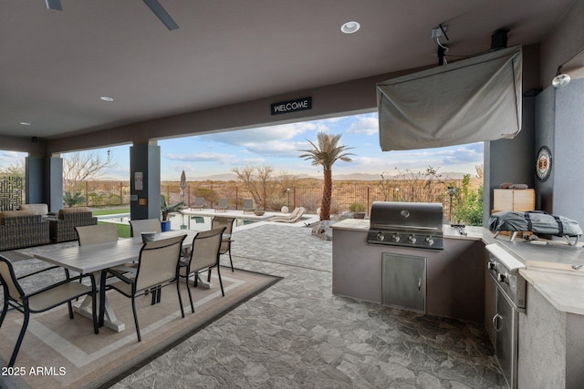 view of patio / terrace with area for grilling, a grill, fence, outdoor dining area, and a swimming pool