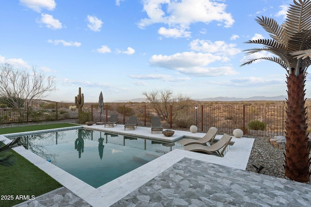 view of swimming pool with a fenced backyard, a patio, and a mountain view