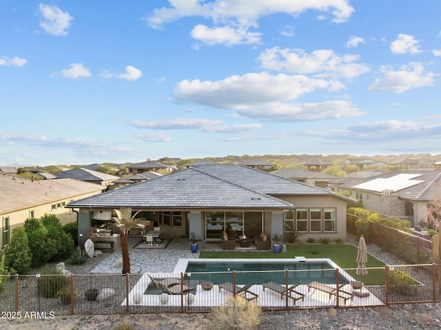 back of property with a patio, outdoor lounge area, a fenced backyard, and a tiled roof