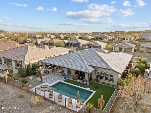 back of house with a patio, outdoor dry bar, a lawn, a residential view, and a fenced backyard