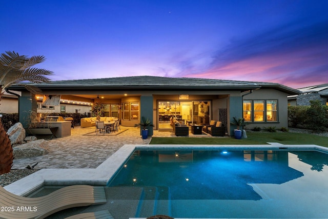 pool with an outdoor hangout area, exterior kitchen, and a patio area