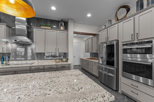 kitchen featuring wall chimney range hood, tasteful backsplash, appliances with stainless steel finishes, and gray cabinets