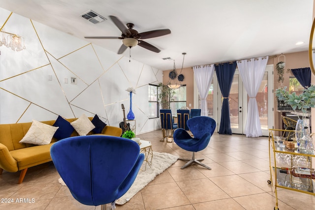 living area with tile patterned floors and ceiling fan with notable chandelier