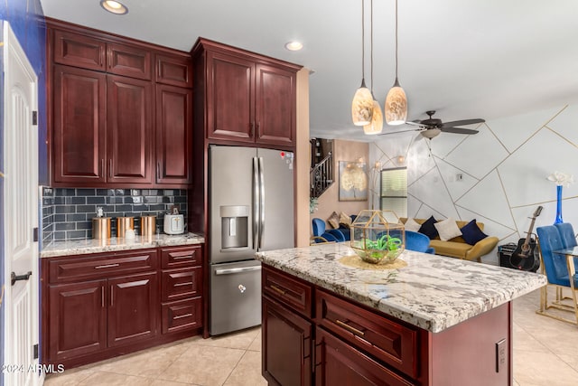 kitchen with ceiling fan, a center island, stainless steel fridge, decorative light fixtures, and light tile patterned flooring