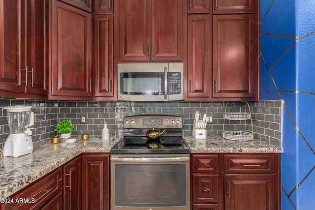 kitchen with decorative backsplash, stainless steel appliances, and light stone counters