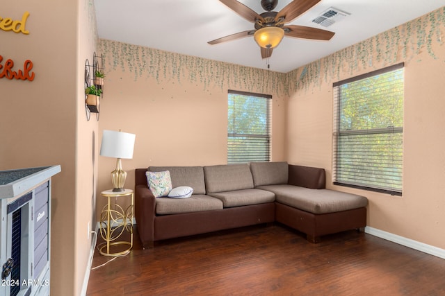 living room featuring ceiling fan, plenty of natural light, and dark wood-type flooring