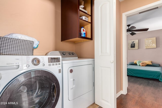 clothes washing area with washing machine and dryer, ceiling fan, and dark wood-type flooring