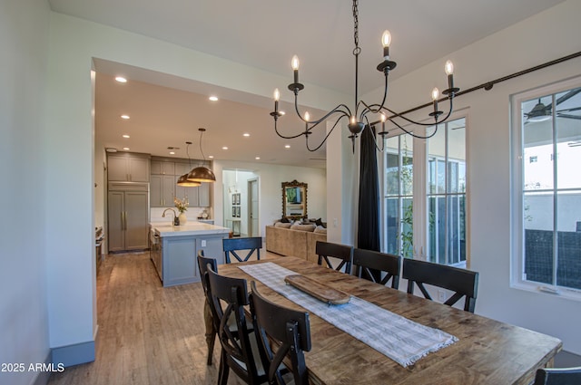 dining room with light hardwood / wood-style flooring, sink, a wealth of natural light, and ceiling fan