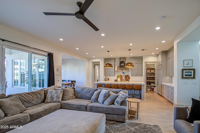 living room with ceiling fan and light hardwood / wood-style flooring