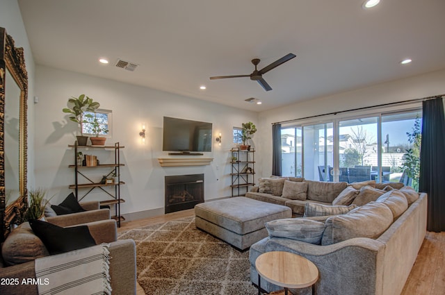 living room featuring light hardwood / wood-style floors and ceiling fan