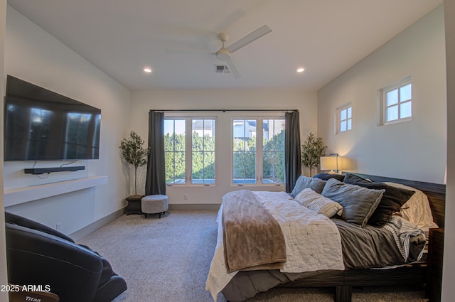 carpeted bedroom with ceiling fan and multiple windows