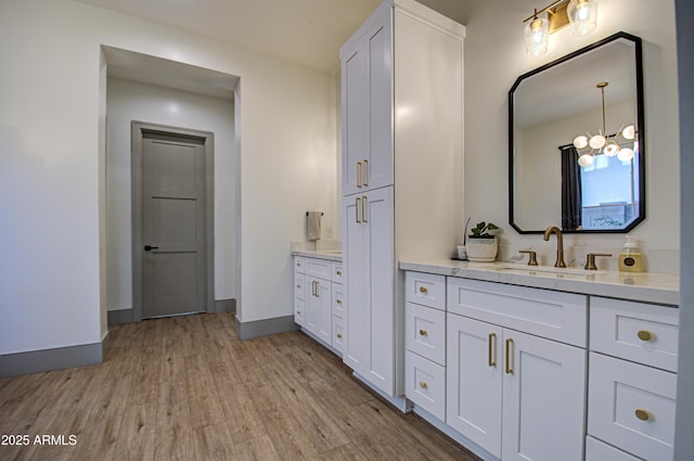 bathroom featuring vanity, hardwood / wood-style floors, and an inviting chandelier