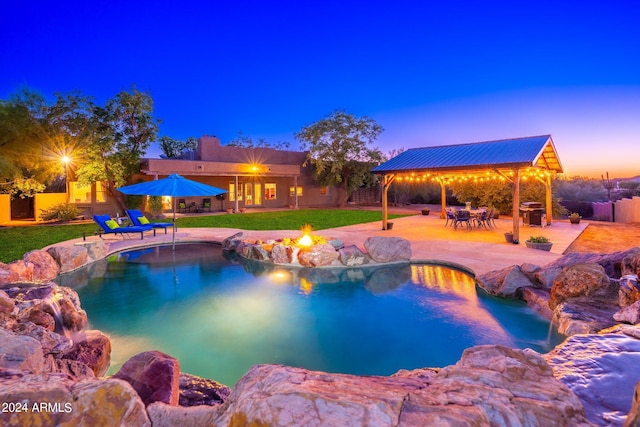 pool at dusk with a gazebo, a patio, a grill, and a yard