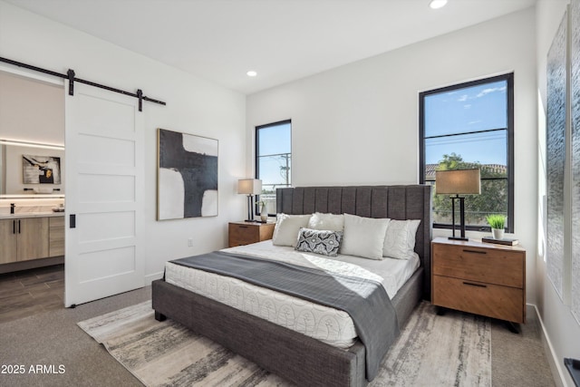 bedroom featuring multiple windows and a barn door