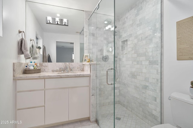 bathroom with a shower with door, toilet, and vanity