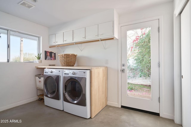 laundry room with cabinets, a wealth of natural light, and washer and dryer