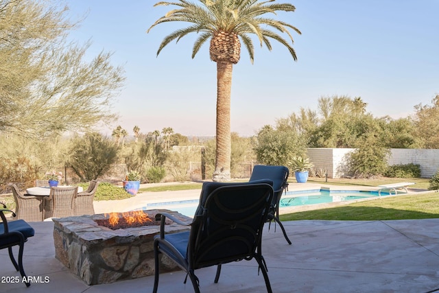 view of patio featuring a fenced in pool and a fire pit