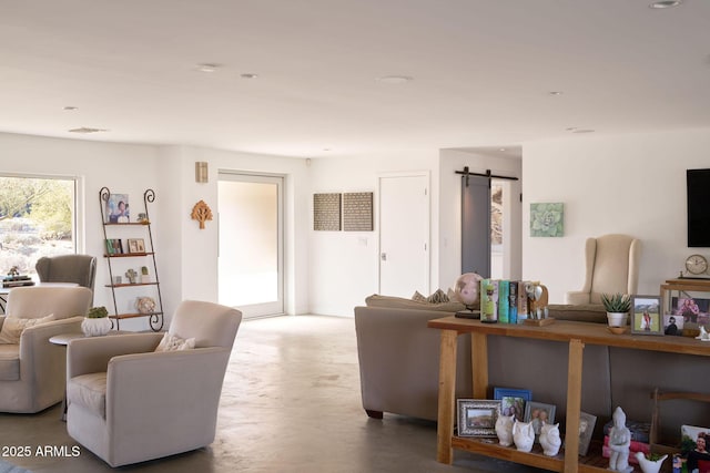 living room with concrete floors and a barn door