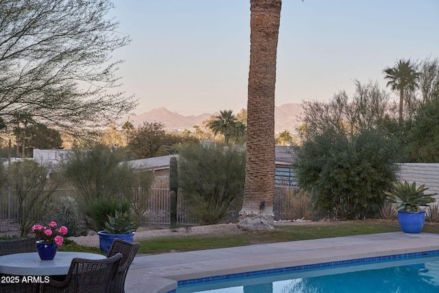 pool at dusk featuring a mountain view