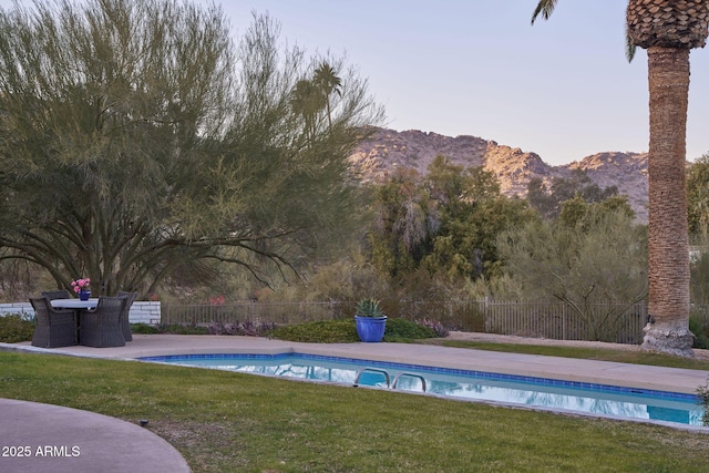 view of pool with a mountain view and a yard