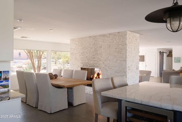 dining space featuring a fireplace and beverage cooler