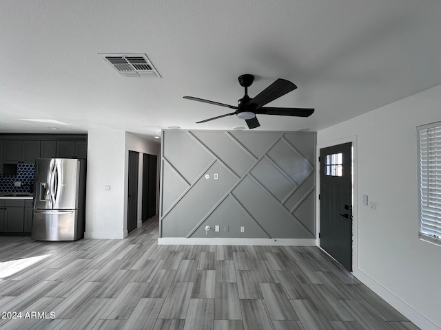 unfurnished living room featuring sink, hardwood / wood-style flooring, and ceiling fan