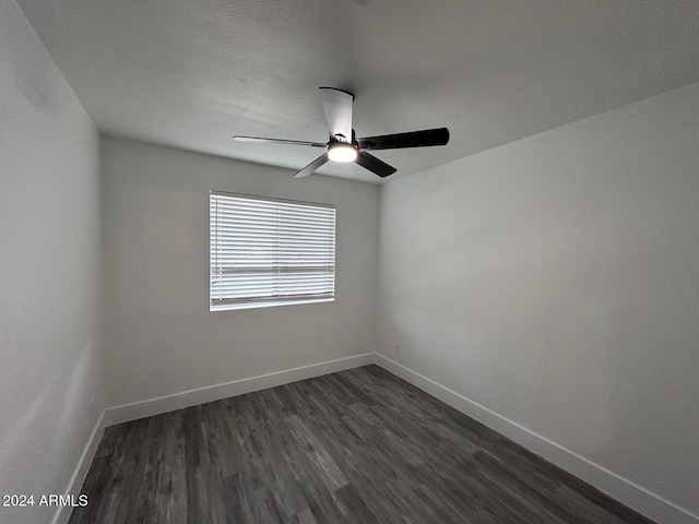 unfurnished room with ceiling fan and dark wood-type flooring