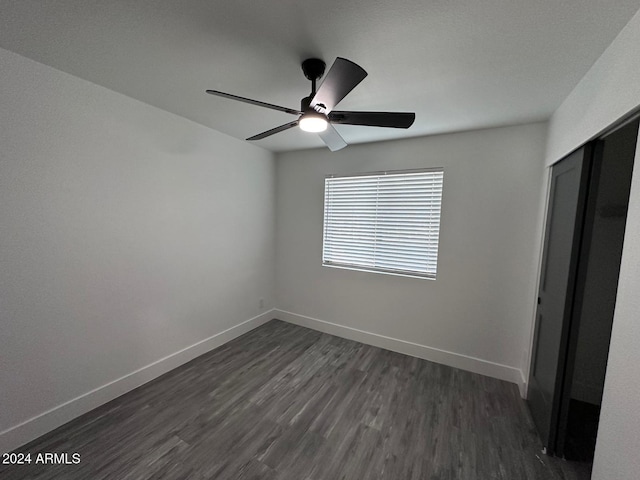 unfurnished bedroom featuring a closet, ceiling fan, and dark hardwood / wood-style flooring