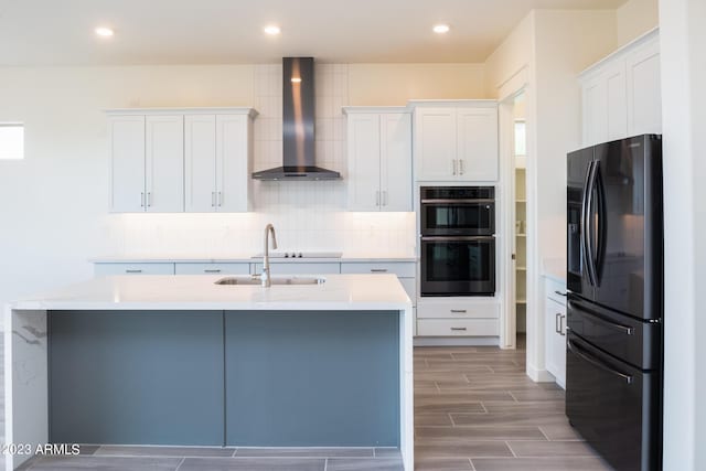 kitchen with double oven, black fridge with ice dispenser, white cabinets, and wall chimney range hood