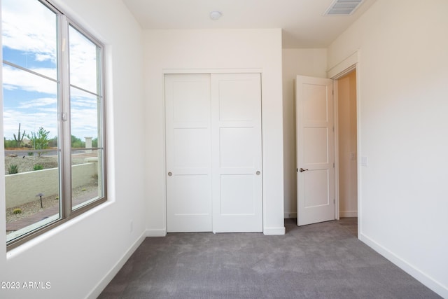 unfurnished bedroom with carpet flooring and a closet