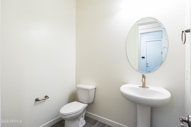 bathroom featuring hardwood / wood-style floors and toilet