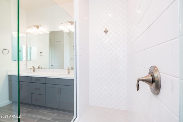 bathroom with tiled shower and vanity