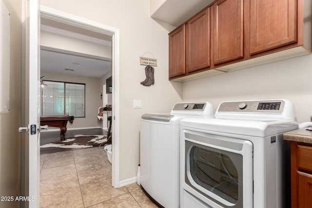 clothes washing area featuring cabinets, separate washer and dryer, and light tile patterned floors