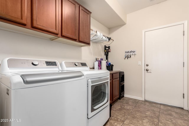 clothes washing area featuring washing machine and dryer and cabinets